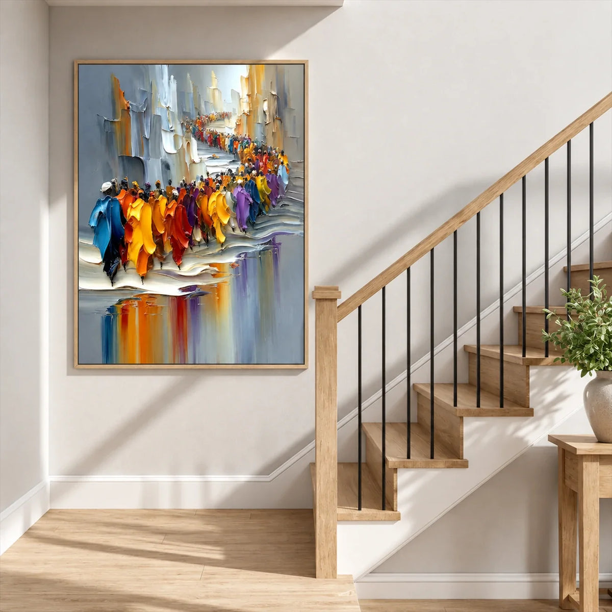 Colorful city parade wall art beside a wooden staircase with black railings and sunlit white walls.