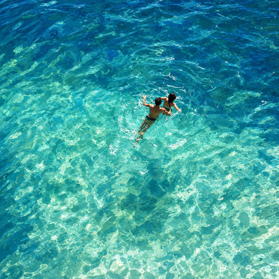 Two Swimmers in Sunlit Turquoise Water Wall Art artwork view | Olyrel