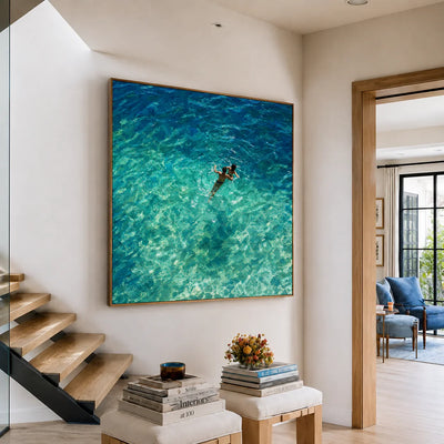 Two Swimmers in Sunlit Turquoise Water Wall Art styled interior scene 1 | Olyrel